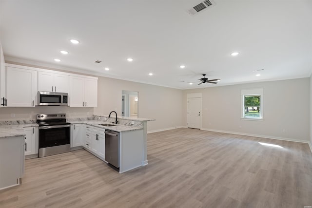 kitchen with visible vents, open floor plan, stainless steel appliances, white cabinetry, and a sink