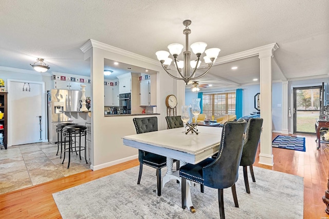 dining room with light wood-style floors, a chandelier, crown molding, and a textured ceiling