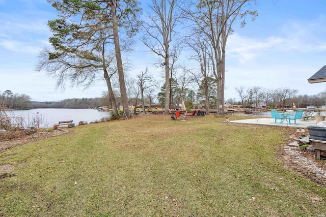 view of yard with a water view and a patio