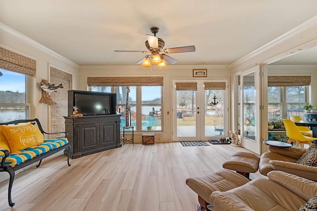 living room featuring light wood finished floors, crown molding, and french doors