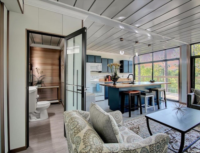 sunroom featuring wooden ceiling and a sink