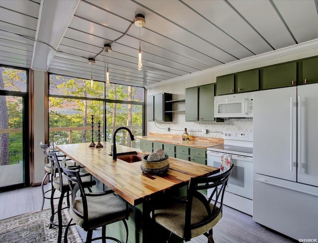 kitchen with light wood-style flooring, a sink, butcher block countertops, white appliances, and green cabinetry