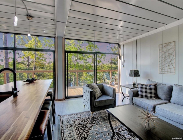 living room featuring expansive windows, crown molding, and wood finished floors
