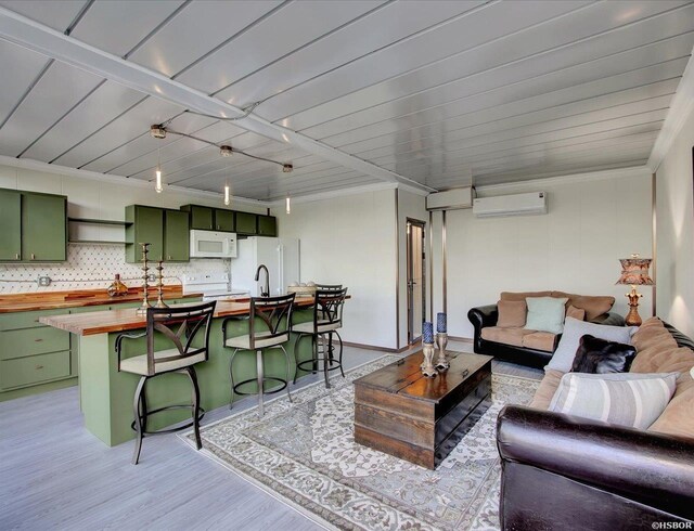 living area with crown molding, light wood-style flooring, and a wall mounted AC