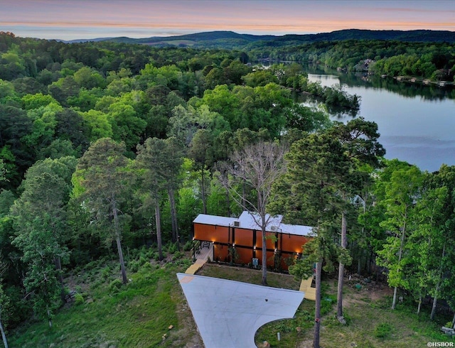 aerial view at dusk with a wooded view and a water and mountain view