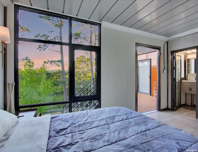 bedroom with ornamental molding, light wood-type flooring, and wood ceiling