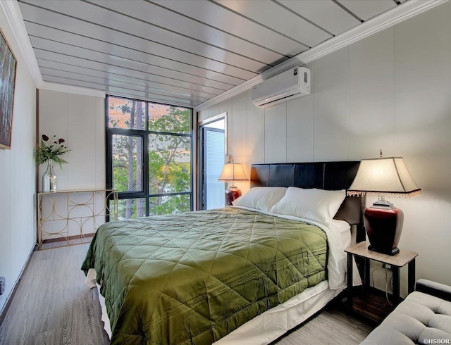 bedroom featuring ornamental molding, an AC wall unit, and wood finished floors