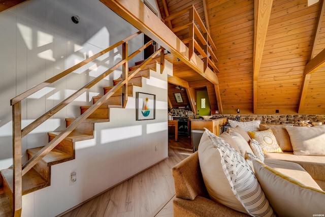 living room with lofted ceiling with beams, stairway, wood finished floors, and wood ceiling