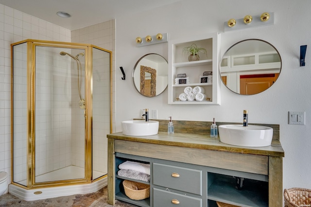 full bathroom with a sink, a shower stall, and double vanity