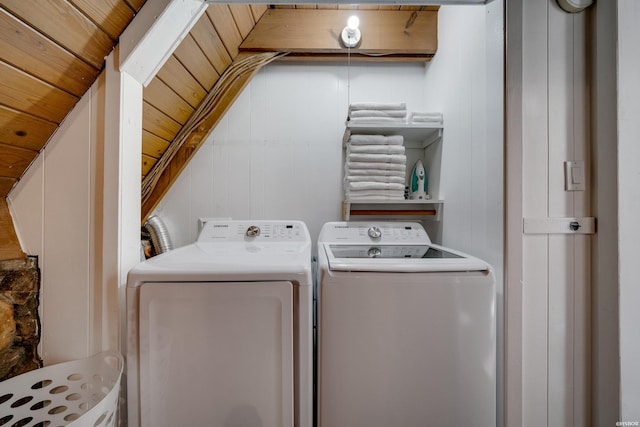 clothes washing area featuring wooden ceiling, laundry area, separate washer and dryer, and wood walls