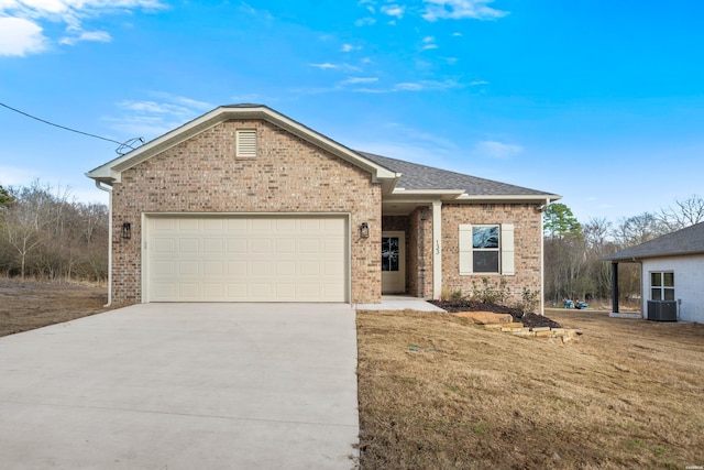 ranch-style house featuring brick siding, roof with shingles, concrete driveway, an attached garage, and a front yard