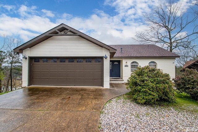 ranch-style home featuring a garage, concrete driveway, brick siding, and roof with shingles