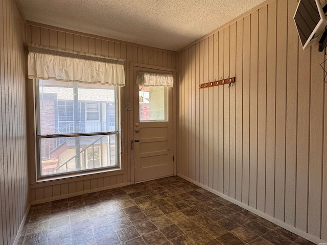 600 Higdon Ferry Rd Unit 203, Hot Springs, AR 71901 - entryway featuring wooden walls, a textured ceiling, baseboards, and dark stone finish floors