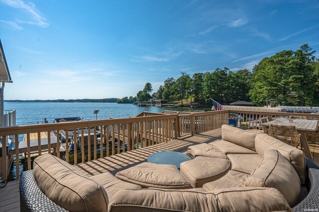 wooden terrace with an outdoor hangout area and a water view