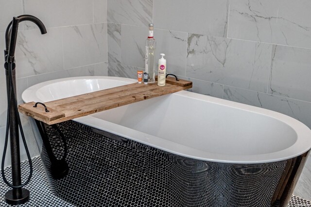 full bath with a freestanding bath and tile walls