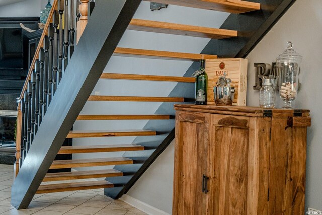 staircase with tile patterned flooring and vaulted ceiling