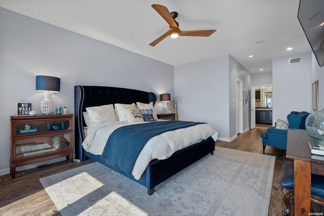 bedroom with baseboards, visible vents, dark wood-type flooring, ensuite bathroom, and recessed lighting