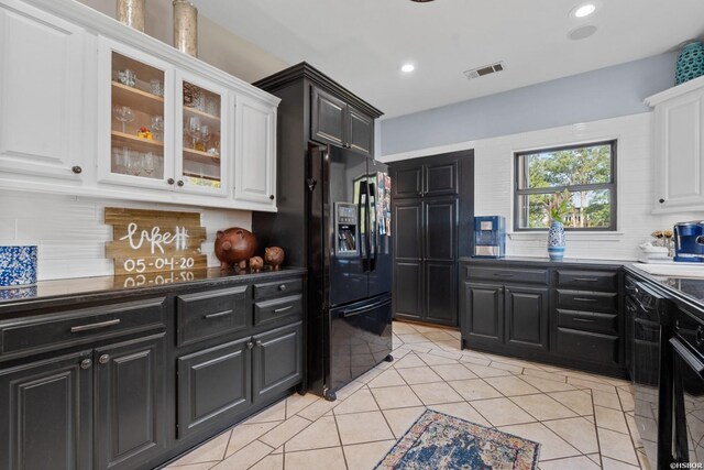 kitchen featuring glass insert cabinets, white cabinetry, visible vents, and black fridge