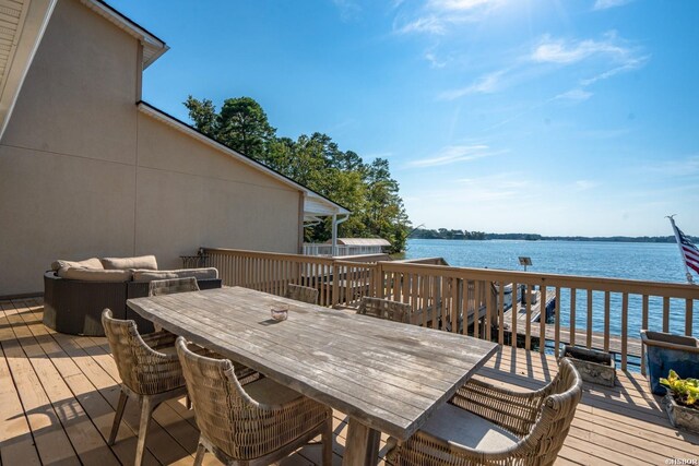 wooden terrace with an outdoor hangout area, outdoor dining space, and a water view