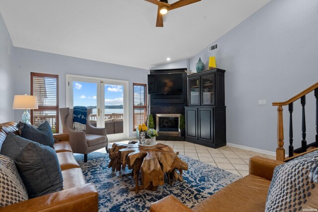 living area with light tile patterned floors, visible vents, a large fireplace, and a wealth of natural light