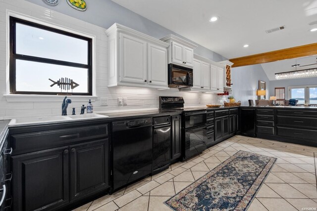 kitchen featuring dark cabinets, white cabinets, light countertops, black appliances, and tasteful backsplash