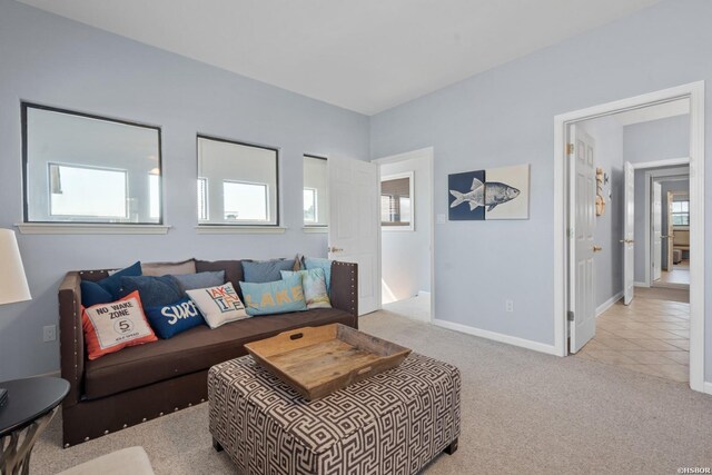 living area featuring baseboards and light colored carpet