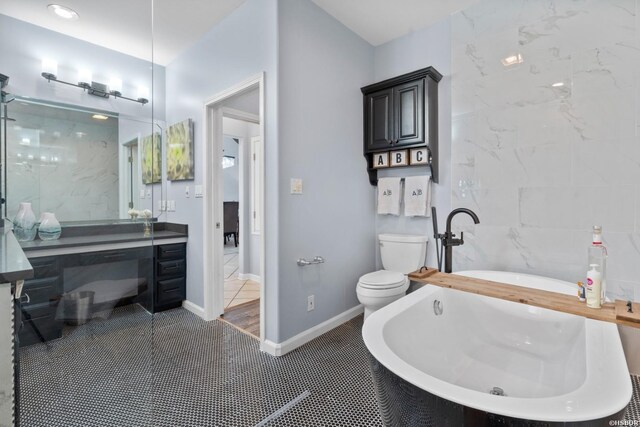 full bathroom with a soaking tub, toilet, vanity, tile patterned flooring, and baseboards