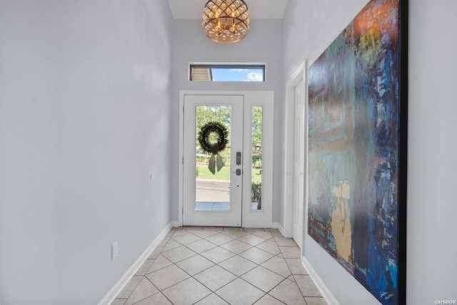 entryway with light tile patterned flooring, baseboards, and an inviting chandelier