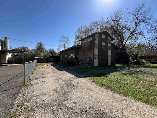 view of home's exterior with driveway and fence