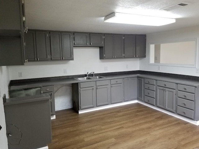 186 Vanadium Cir, Hot Springs, AR 71901 - kitchen with wood finished floors, dark countertops, a sink, gray cabinetry, and visible vents