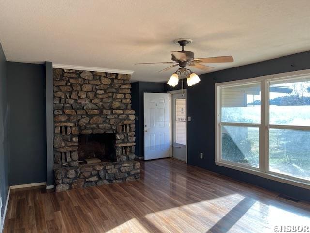 unfurnished living room featuring ceiling fan, visible vents, wood finished floors, and a stone fireplace