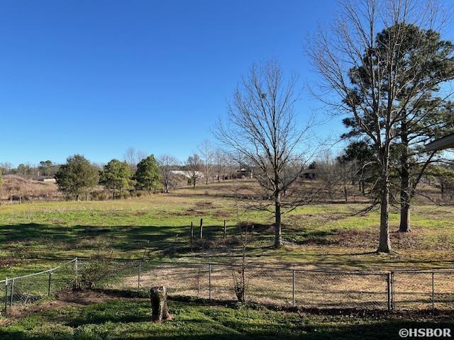 view of yard featuring a rural view and fence