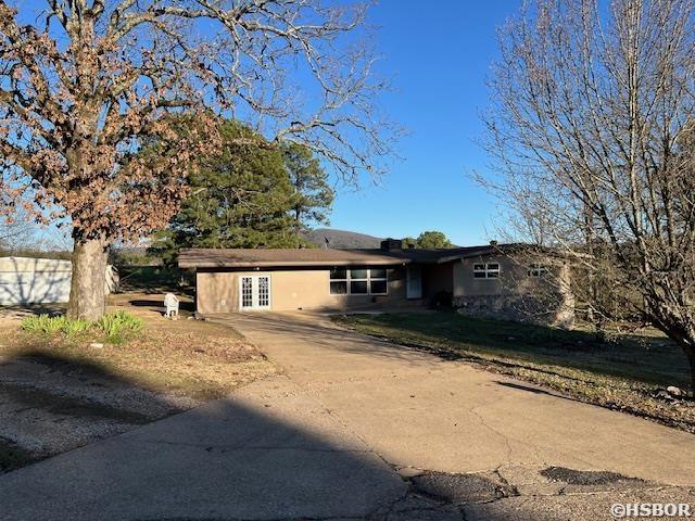 view of front of home with french doors and concrete driveway