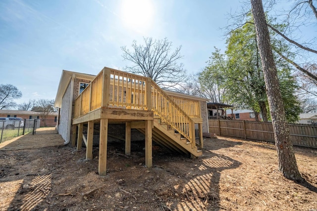 exterior space featuring stairs, fence, and a wooden deck