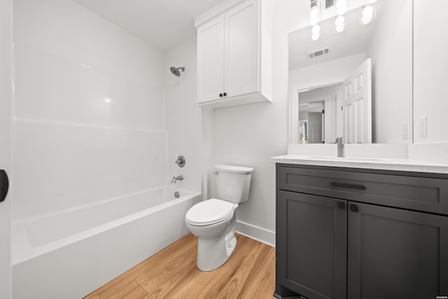 bathroom with shower / bath combination, visible vents, toilet, wood finished floors, and vanity