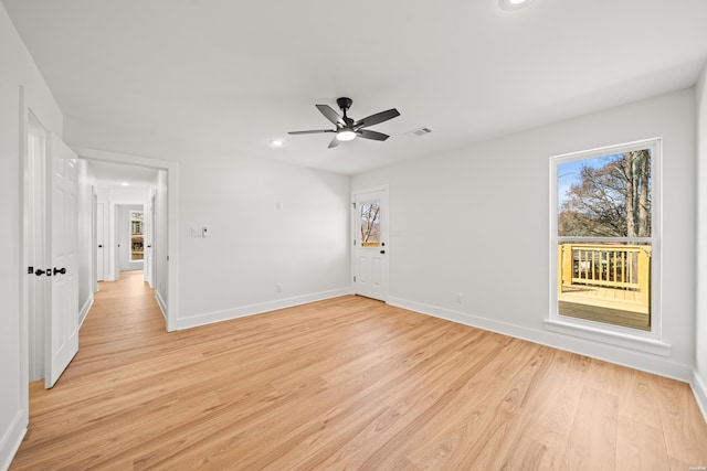 spare room with visible vents, plenty of natural light, light wood-style flooring, and baseboards