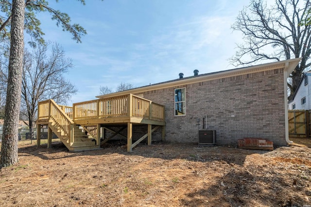 rear view of house with central AC unit, stairs, fence, a deck, and brick siding