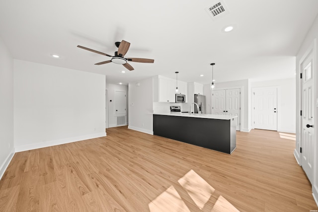 kitchen with light countertops, recessed lighting, white cabinetry, and light wood-style floors