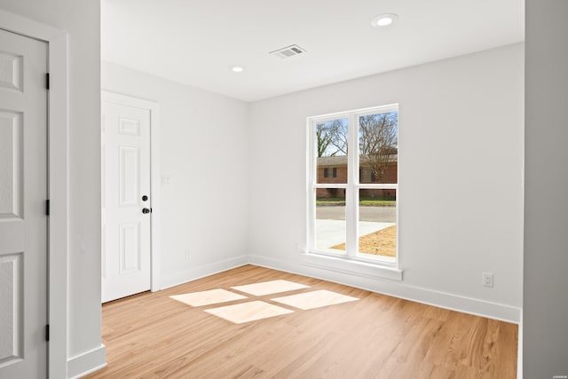 unfurnished room featuring light wood finished floors, recessed lighting, visible vents, and baseboards