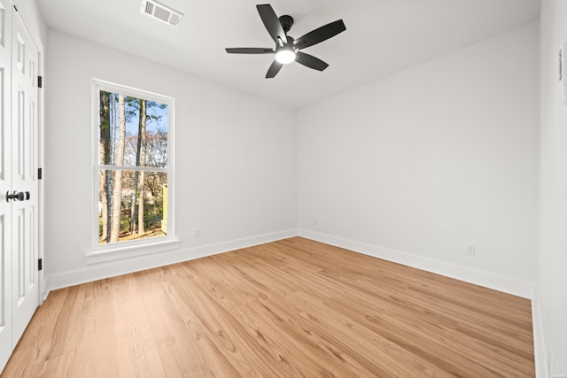 unfurnished room featuring light wood-style floors, baseboards, visible vents, and ceiling fan