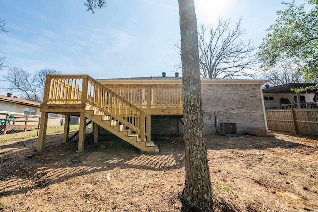 back of property featuring stairs, fence, a deck, and brick siding