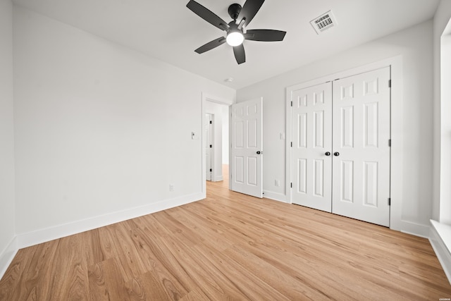 unfurnished bedroom with a closet, visible vents, a ceiling fan, light wood-type flooring, and baseboards