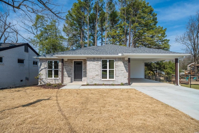 view of front of house featuring driveway, an attached carport, roof with shingles, a front lawn, and brick siding