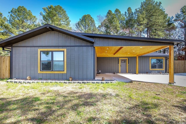 view of front of home with a patio, a front lawn, and fence