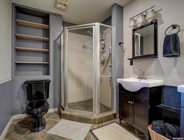 full bath with a stall shower, baseboards, and vanity