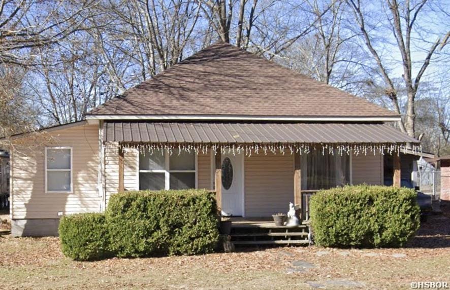 view of front of house featuring covered porch and a shingled roof