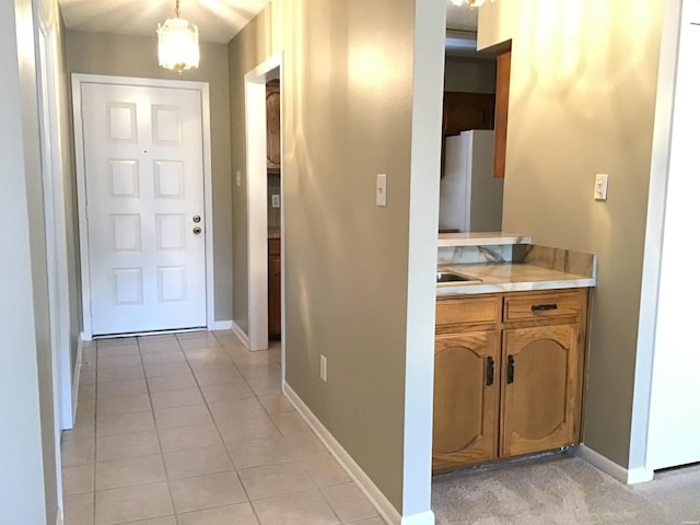 hallway with light tile patterned floors and baseboards