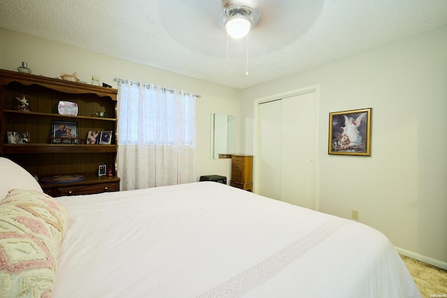 bedroom featuring ceiling fan, a closet, baseboards, and carpet