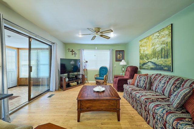 living room with light wood finished floors and a ceiling fan