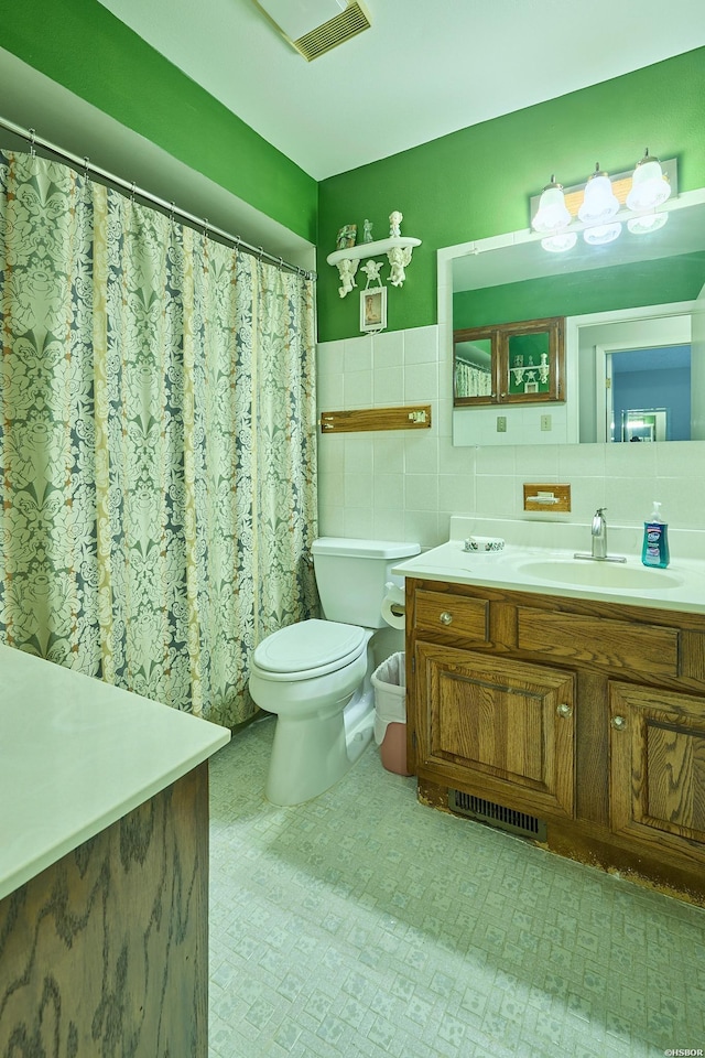 bathroom featuring toilet, tile walls, vanity, and visible vents